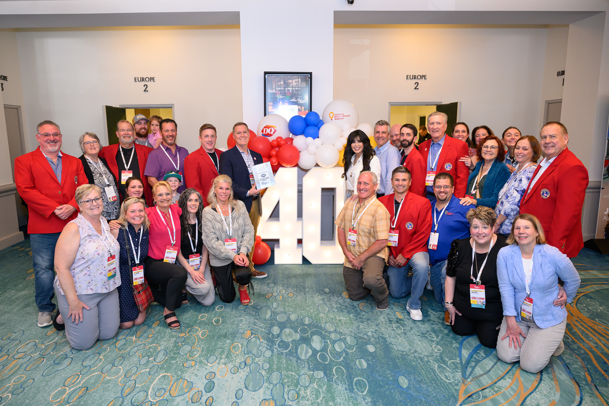 Franchisees standing in front of 40th anniversary letters