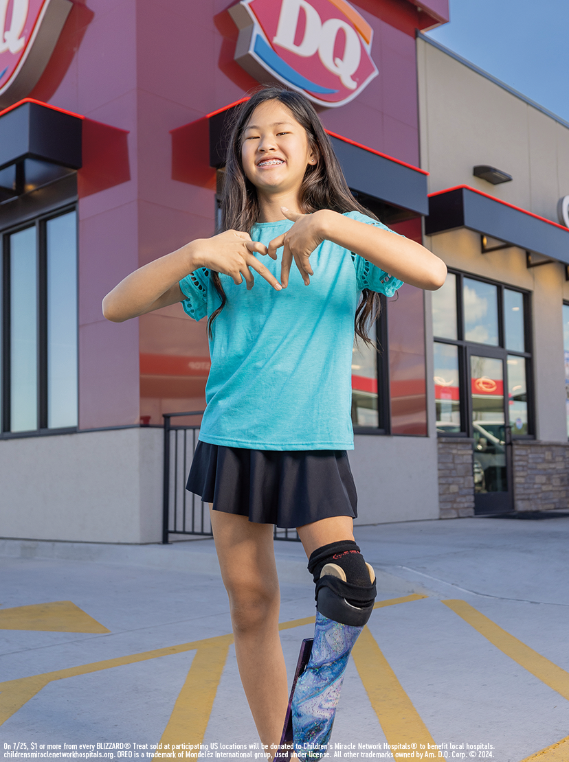 Girl standing in front of a Dairy Queen store